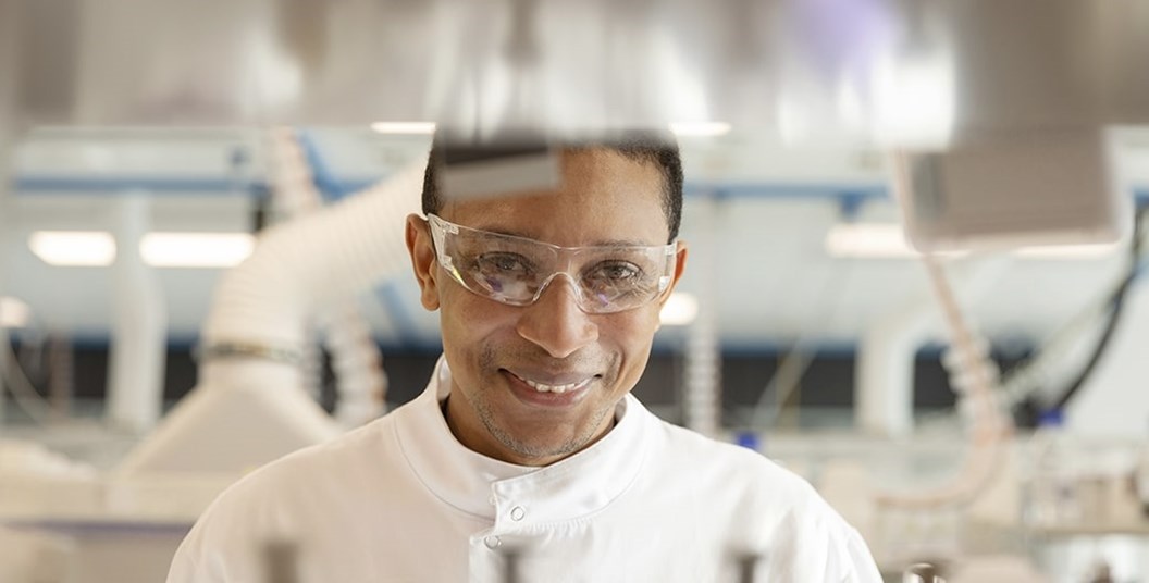 Homem sorrindo em um laboratório.